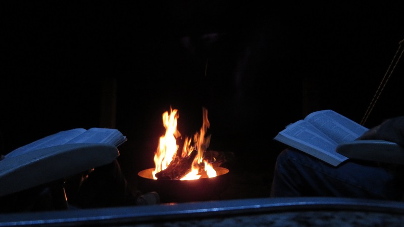 Readibg Bible by campfire