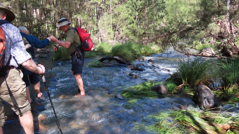 Hikers crossing flooded creek